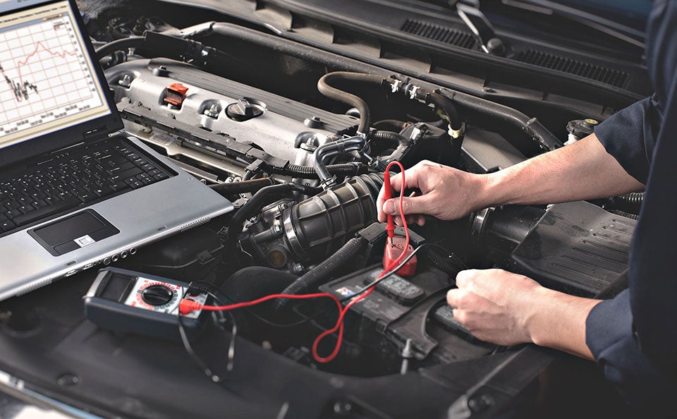 A Ford technician checking a car battery near Lancaster, OH.